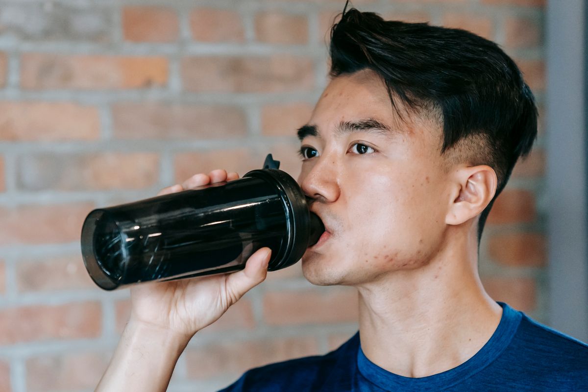 Sportif buvant dans un shaker pendant son entraînement